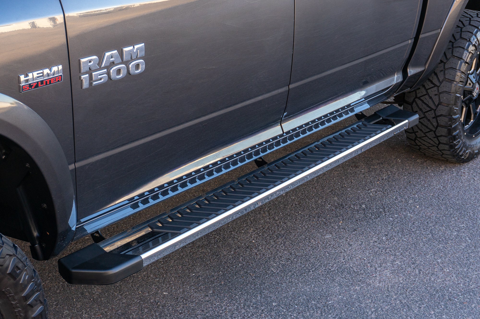 An image of a grey RAM 1500 with CYC Engineering's OEM style full tread running boards installed. 