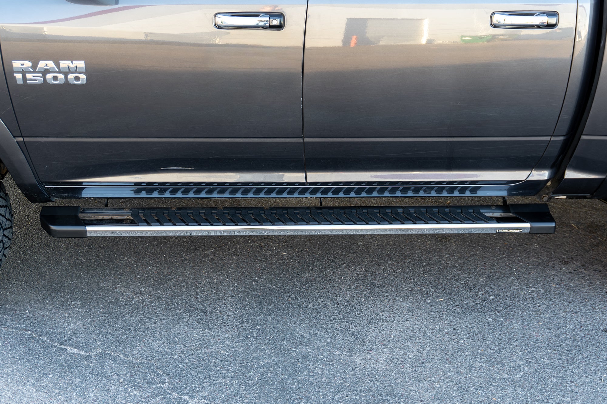 An image of a grey RAM 1500 with CYC Engineering's OEM style full tread running boards installed. 
