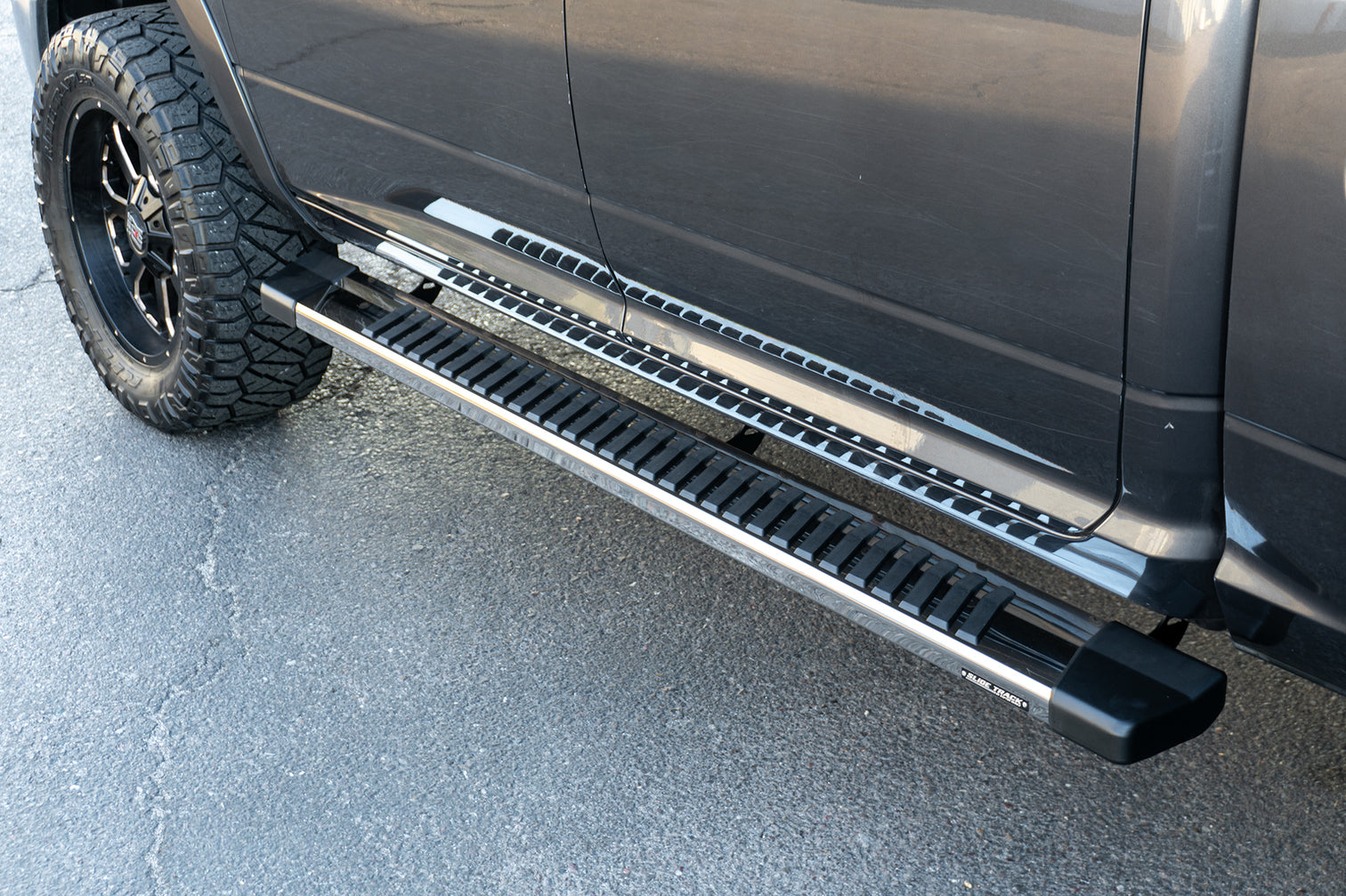 An image of a grey RAM 1500 with CYC Engineering's OEM style full tread running boards installed. 