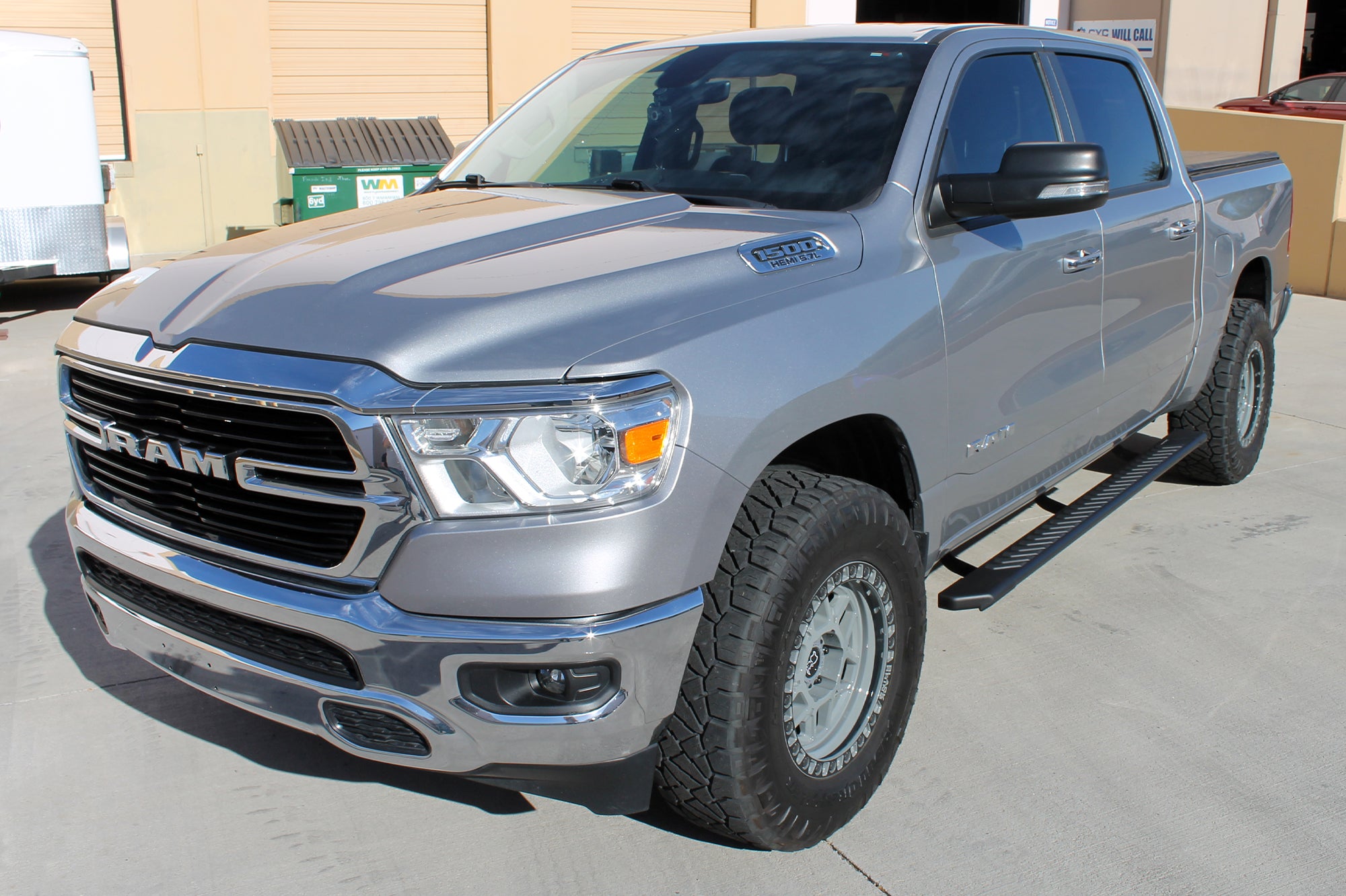 CYC Engineering's 5 inch OEM Style Full Tread Slide Track Running Boards in Black Textured Aluminum on a silver Dodge Ram.