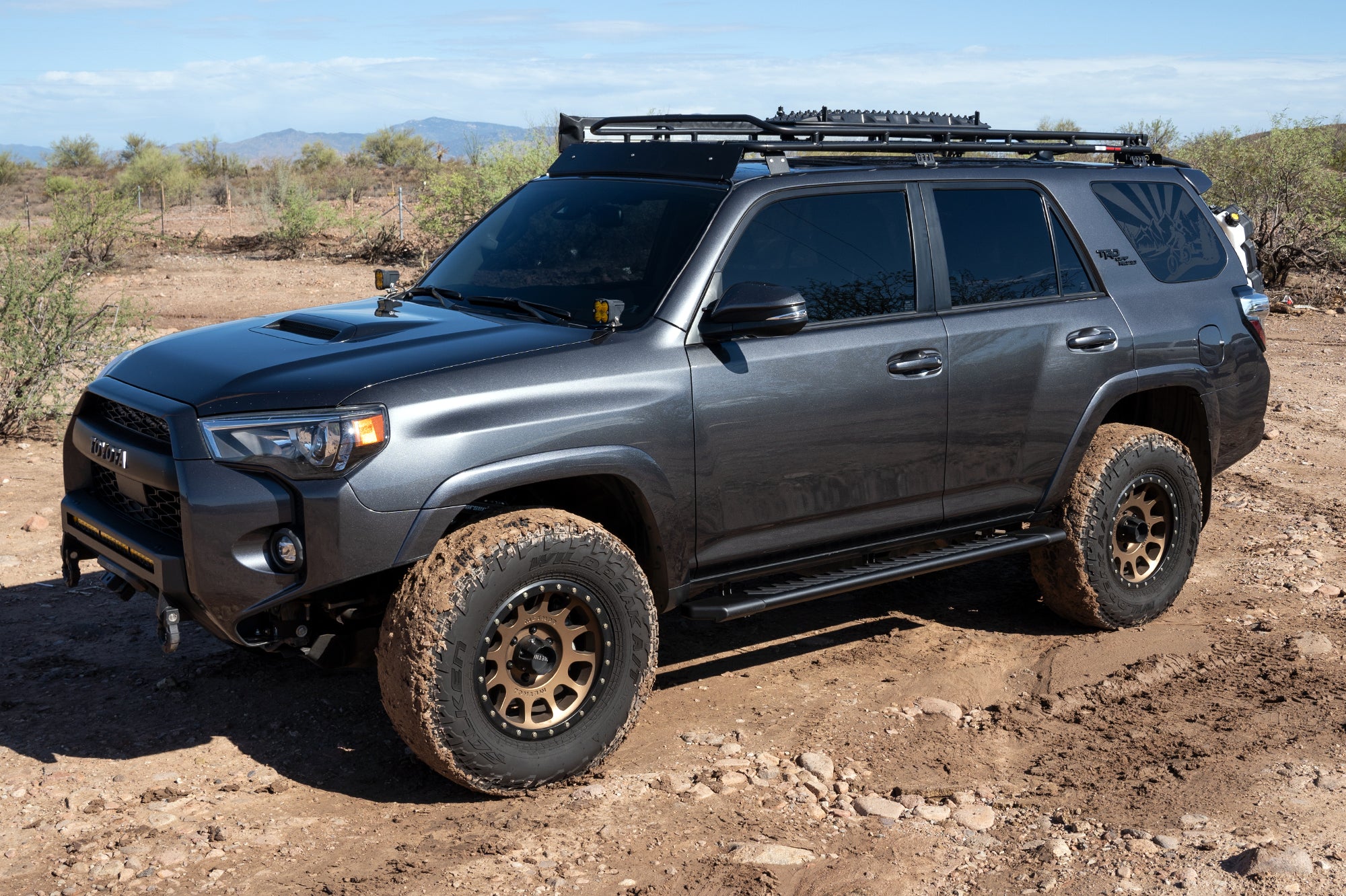 CYC Engineering's 5 inch OEM Style Full Tread Slide Track Running Boards in Black Textured Aluminum on a grey Jeep.